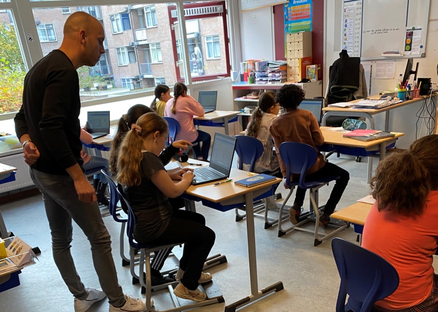Kinderen achter een computer in een klaslokaal